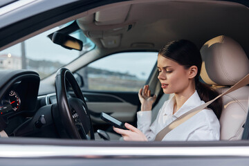 Woman driving car, holding cell phone, and looking at screen, reflecting distracted driving concept