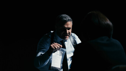 Furious detective screaming at interrogated person, threatening with violence