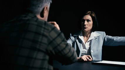 Police detective arguing with an arrested man refusing to sign papers