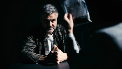 Police detective questioning a detained man about evidence, investigation process