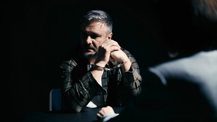 Female attorney talking to an arrested client in private, giving advice, legal aid