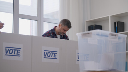 Middle-aged man voting at a polling station, presidential election day, democracy