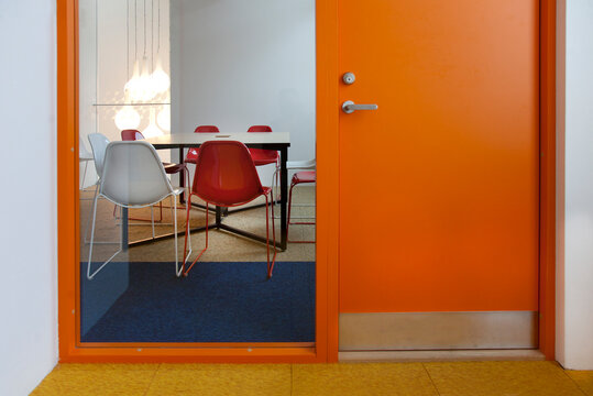 Modern meeting area in an office or college, a glass panel annd view into a small room.