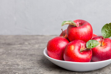 juicy red apples in a bowl or plate on the table top view. Copy space