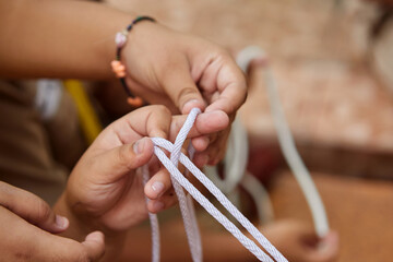 Boy Scout learning tie the knot pattern in classroom