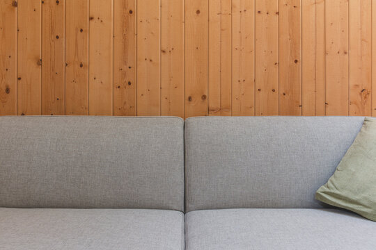 Detail of modern couch against wood panel wall