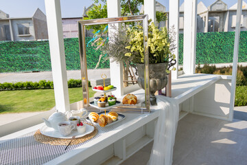 A backyard picnic is a fun and casual outdoor gathering, perfect for enjoying fresh air and good company in the comfort of your own home. Set up a cozy space with blankets, cushions, and a low table 