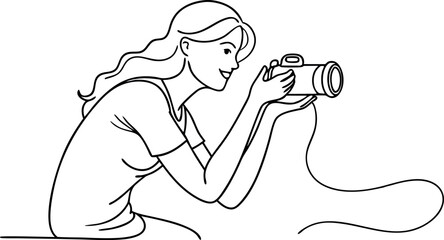A woman is taking a picture with a camera. She is smiling and looking at the camera. The camera is in her hand and the cord is attached to it