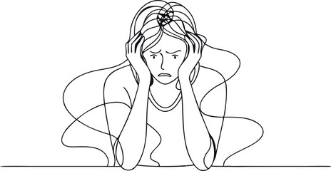 A woman is sitting at a table with her head in her hands. She looks sad and is probably feeling overwhelmed or stressed
