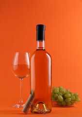 Obraz premium Wine, corkscrew and fresh grapes on orange background