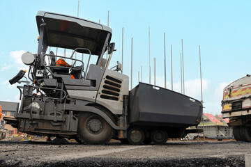 Construction Workers Operate Heavy Machinery on a Road Project at Daytime in an Urban Environment