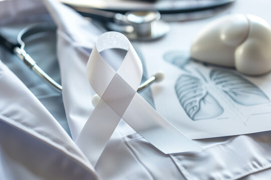 A white awareness ribbon pinned to medical gown for lung cancer awareness campaign 