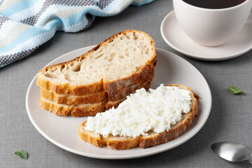 Bread with cottage cheese on grey table, closeup