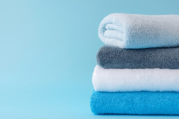 清潔なタオル。きれいに畳まれた洗濯物。青い背景。