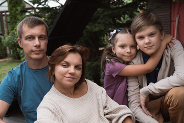 family poses for picture together while sitting in backyard