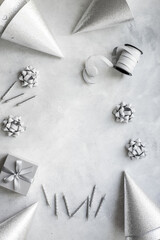 Birthday party celebration frame with silver party hats and cake candles, top view