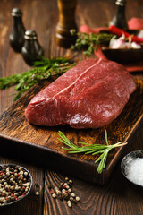 Raw beef top round steak on wooden cutting board
