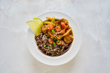 Top view of spicy black rice noodles with shrimps and mushrooms