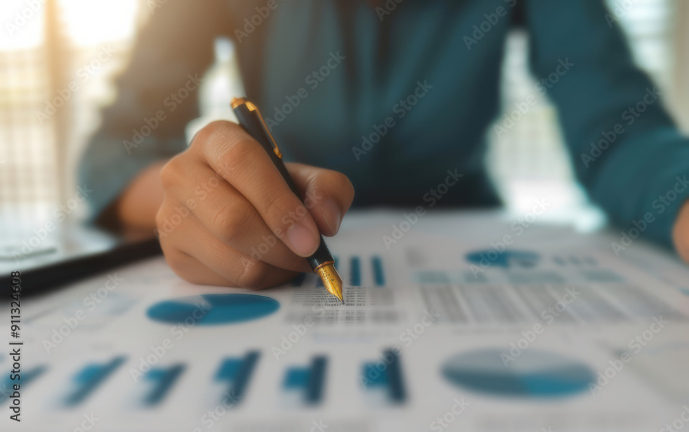 Poster close-up of a person analyzing financial charts with a pen, focusing on business data and statistics