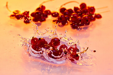 Fresh red currants hit water with energetic splash, capturing essence of summer's vibrant and juicy...