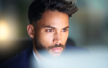 Obraz premium Thinking, night and man in office, laptop and test of software for cybersecurity, programmer and bokeh. Serious, overtime and employee for coding of website, IT and information technology in dark