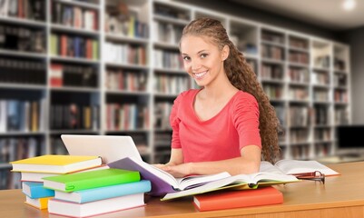 Happy thinking woman student study in library