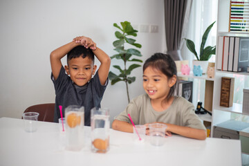 Two children are playing with a science experiment involving water and eggs