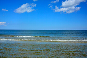 niebieskie morze z niebieskim niebiem i białymi, pierzastymi chmurami, morski krajobraz, pogodne niebo nad morzem, horyzont, blue sea with blue sky, sea landscape, horizon, © kateej