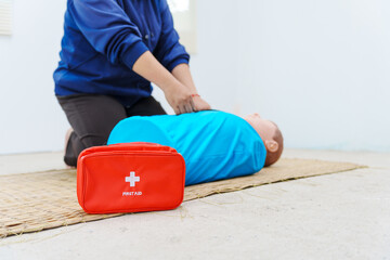 A woman performs chest compressions on a dummy during a CPR training class, demonstrating life-saving techniques and emergency response skills to ensure preparedness in critical situations.