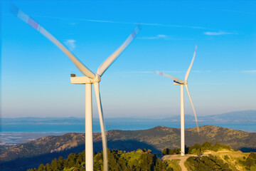 Wind turbines produce zero emission energy in the green hills, modern power plant, alternative energy sources