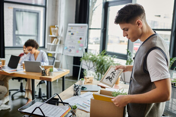 Man packing for a layoff, colleagues on backdrop.