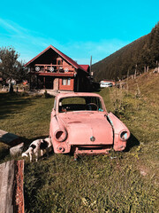 An old abandoned car stands near a road in the mountains. Abandoned car concept