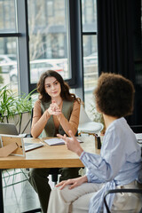 Two well-dressed colleagues converse during a challenging work moment.
