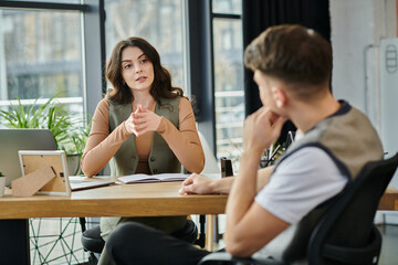 Colleagues discuss the sensitive layoff process in a modern office setting.