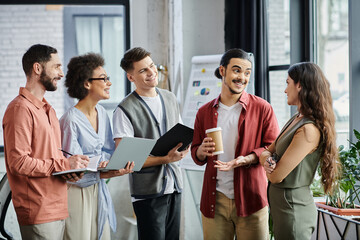 Team members converse amicably in a stylish workspace during a challenging time.