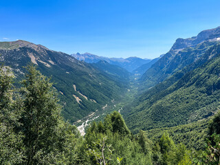 Fototapeta premium Scenic mountain valley in Monte Perdido and Ordesa in Pyrenees in Spain with wildflowers under cloudy sky.