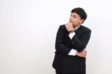 Photo of young asian businessman hand touch chin look empty space guess interested wonder isolated over white background