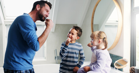 Fototapeta premium Father, bathroom and brushing teeth with children in home for morning routine, dental hygiene and oral health. Dad, siblings and teaching with toothbrush for cleaning mouth, bonding and wellness.