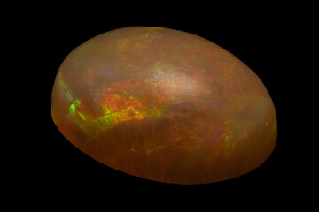 natural rainbow opal gem isolated on black background