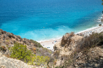 Beautiful beach with clear blue waters and white sand in Cala Moraig, Spain