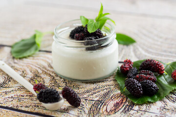 homemade sweet yogurt in a jar with black mulberries