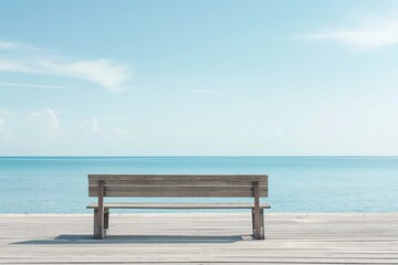 An empty wooden bench sits on a boardwalk facing the calm and serene blue ocean, invoking peace and solitude.