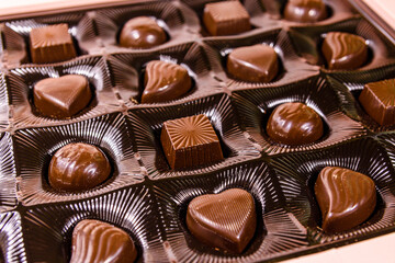 Heap of chocolate candies in a brown box
