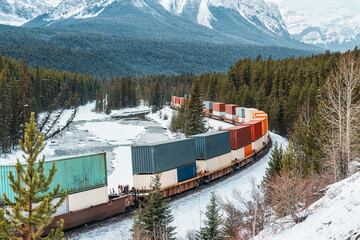 A freight train carrying container passing through the Bow Valley on winter at Morants Curve