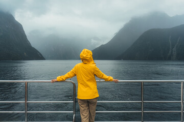 Young female enjoying the view of Milford Sound during ferry cruise on vacation at New Zealand