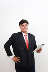 Portrait of a young Asian male businessman in formal suit standing holding tablet computer. Isolated in white background