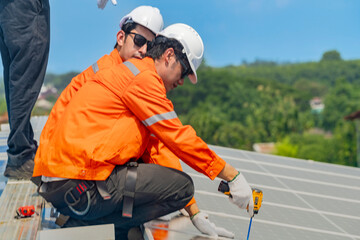 Worker Technicians are working to construct solar panels system on roof. Installing solar photovoltaic panel system. Men technicians walking on roof structure to check photovoltaic solar modules.