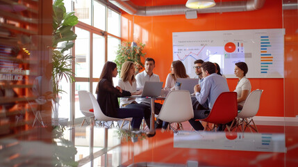 A dynamic business meeting in a modern office with a diverse team, charts, and laptops, showcasing professional collaboration."