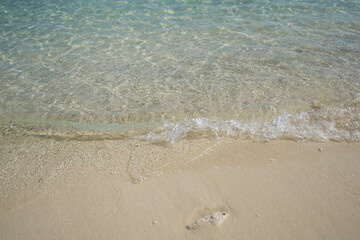 Waves on the edge of the sand on the beaches in the Bahamas. Natural background.