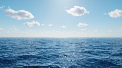 Obraz premium A serene ocean view with gentle waves, reflecting a clear blue sky and sparse clouds, creating a peaceful atmosphere